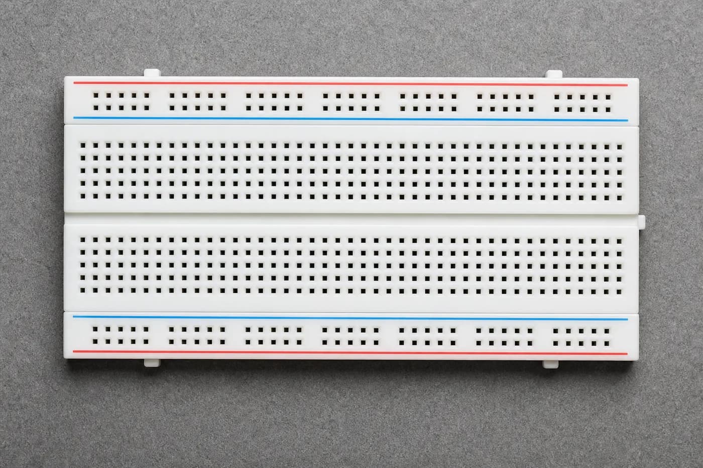 White breadboard showing power rails and component sections for beginners White breadboard showing power rails and component sections for beginners